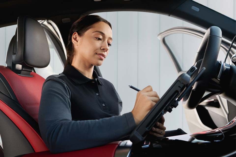Woman in a car filling out a checklist
